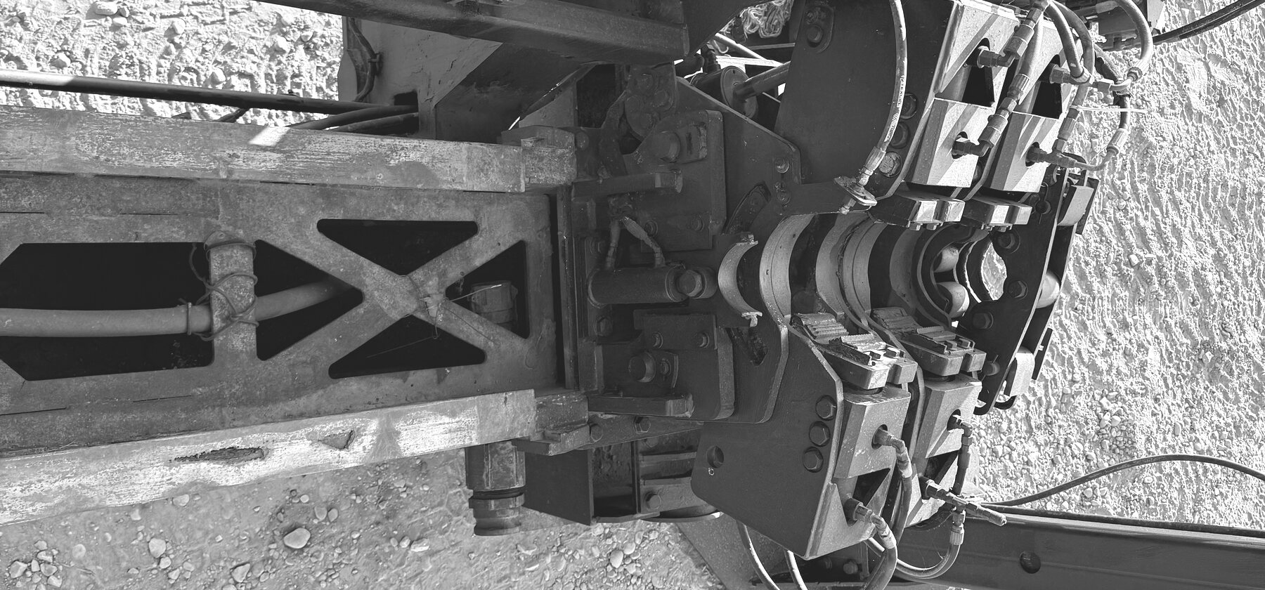 A rod-carousel clamp and cross-braced mast on a horizontal directional drill, shot at a steep angle