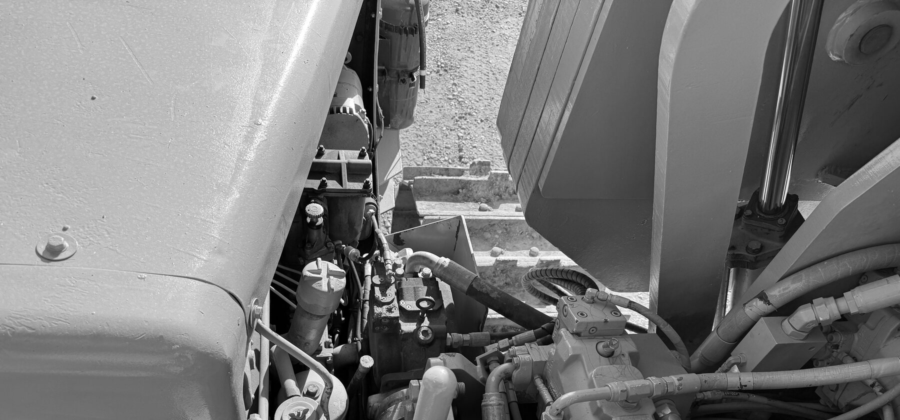 A fuel filter and hydraulic valve assembly in a pipelayer engine bay, track visible behind