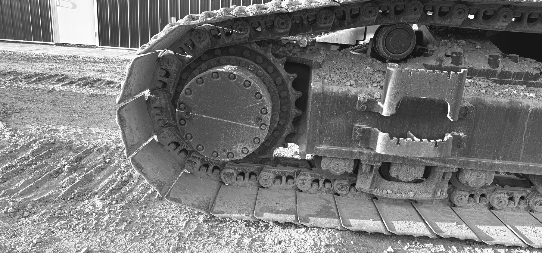A sprocket and track chain on an excavator undercarriage
