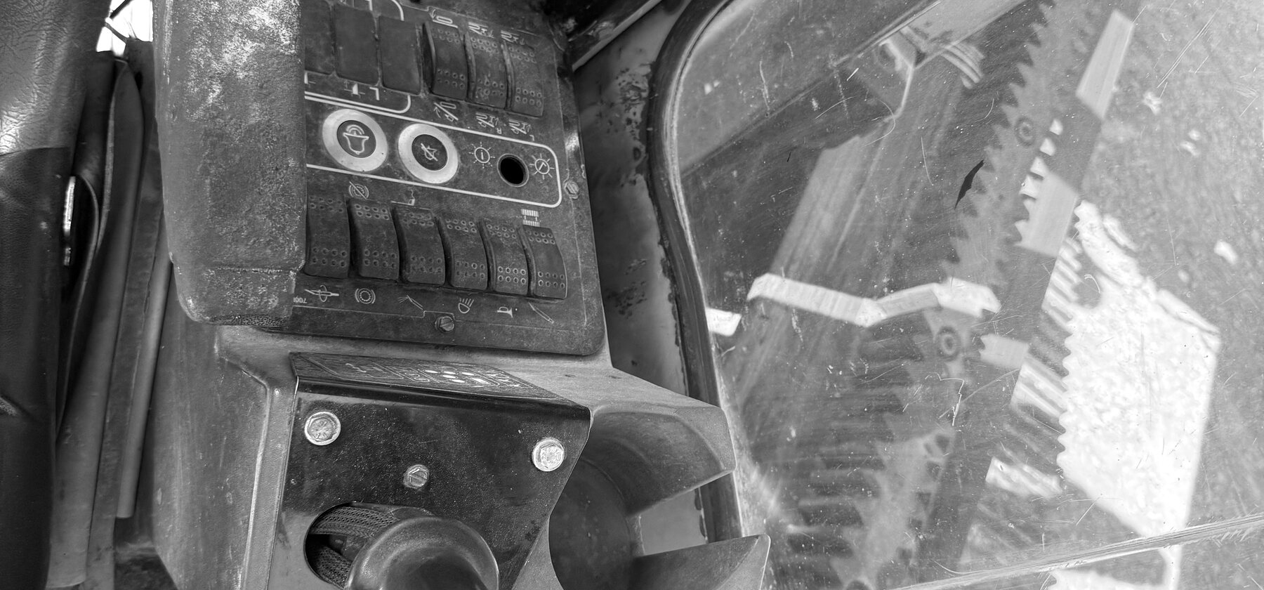 A drill rig cab's joystick and switch panel, worn smooth from use