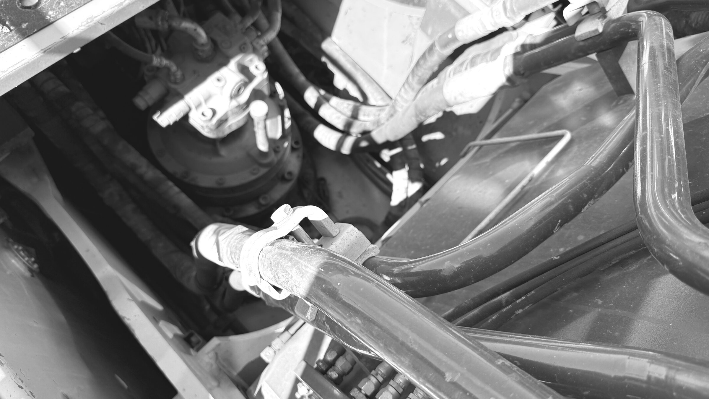 Hydraulic hoses and a valve block routed through an excavator's swing-motor housing