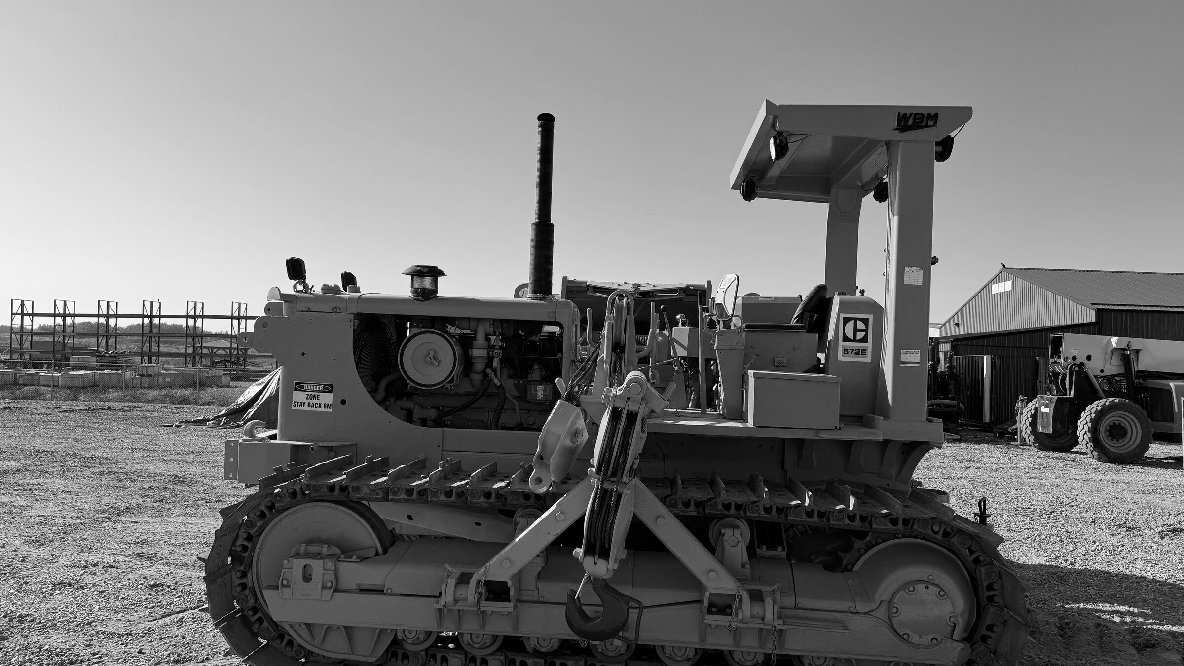 A tracked pipelayer with its counterweight out, standing in a yard